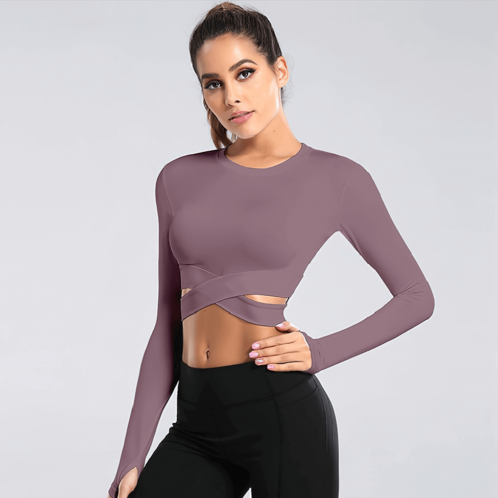 Woman wearing slim crew neck crop top with cross waist, long sleeves, perfect for yoga. Stylish and breathable fitness wear.